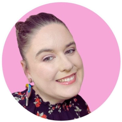 Profile Photo of Ashleigh, standing in-front of a wall that contains a rocket ship